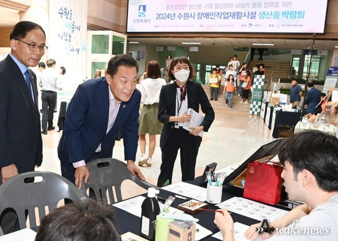 이재준 수원시장이 박람회에서 생산품을 보고 있다.