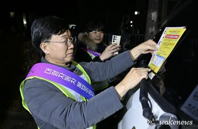 이민근 안산시장이 20일 새벽시간, 단원구 와동 일대에 불법 밤샘주차된 대형차랑에 계도문을 부착하고 있다.