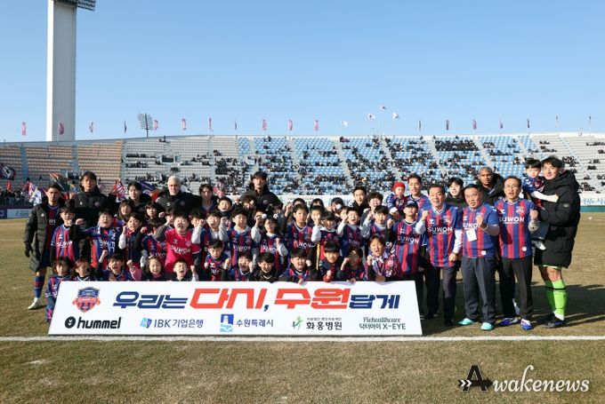 이재식 수원특례시의회 의장을 비롯한 내빈들과 어린이들이 「2026 시즌 K리그2 수원FC 홈 개막전」을 앞두고 기념촬영을 하고 있다.