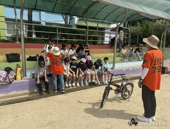 학교 운동장에서 학생들이 자전거 보호장구 착용 요령 교육을 받고 있다.
